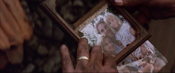 Movie still from “A Time to Kill” (1996), directed by Joel Schumacher – A person holding a picture of a family in a box; Extreme Close Up shot, High angle