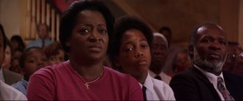 Movie still from “A Time to Kill” (1996), directed by Joel Schumacher – A woman and a boy are sitting in front of other people; Close Up shot, Low angle