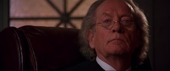 Movie still from “A Time to Kill” (1996), directed by Joel Schumacher – An old man with glasses and a white beard looking at the camera; Close Up shot, Low angle