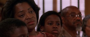 Movie still from “A Time to Kill” (1996), directed by Joel Schumacher – A person sitting next to another person; Close Up shot, Over the shoulder angle