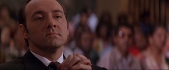 Movie still from “A Time to Kill” (1996), directed by Joel Schumacher – A man in a suit and tie clasps his hands; Close Up shot, Low angle