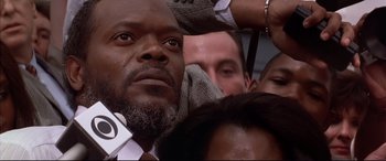 Movie still from “A Time to Kill” (1996), directed by Joel Schumacher – A man's face as he is surrounded by other people; Close Up shot, Low angle