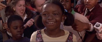 Movie still from “A Time to Kill” (1996), directed by Joel Schumacher – A young girl smiling for the camera with her pigtails in her hair; Close Up shot, Low angle