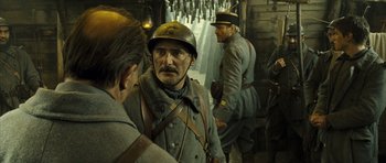 Movie still from “A Very Long Engagement” (2004), directed by Jean-Pierre Jeunet – A group of men standing next to each other in uniforms; Medium shot, Over the shoulder angle