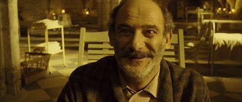 Movie still from “A Very Long Engagement” (2004), directed by Jean-Pierre Jeunet – An older man with a beard and a mustache; Close Up shot, High angle