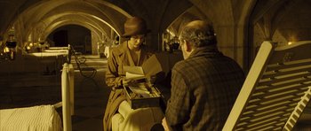 Movie still from “A Very Long Engagement” (2004), directed by Jean-Pierre Jeunet – A man and a woman are looking at papers in a box; Medium shot, Over the shoulder angle