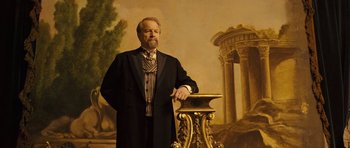Movie still from “A Very Long Engagement” (2004), directed by Jean-Pierre Jeunet – A man standing in front of an oil painting; Medium shot, Low angle