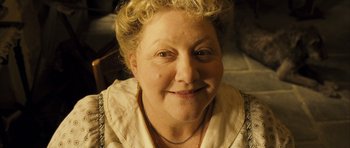 Movie still from “A Very Long Engagement” (2004), directed by Jean-Pierre Jeunet – An older woman with blonde curly hair smiling for the camera; Close Up shot, High angle