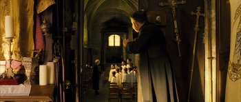 Movie still from “A Very Long Engagement” (2004), directed by Jean-Pierre Jeunet – A group of people standing in a room with candles; Wide shot, High angle