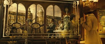 Movie still from “A Very Long Engagement” (2004), directed by Jean-Pierre Jeunet – A group of people sitting at a table in front of a window; Wide shot, Low angle