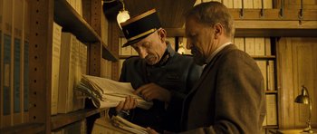 Movie still from “A Very Long Engagement” (2004), directed by Jean-Pierre Jeunet – Two men in uniform looking at a newspaper; Medium shot, Low angle