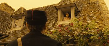 Movie still from “A Very Long Engagement” (2004), directed by Jean-Pierre Jeunet – A man standing in front of a woman looking out of a window; Wide shot, Over the shoulder angle