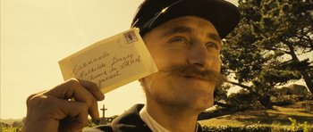 Movie still from “A Very Long Engagement” (2004), directed by Jean-Pierre Jeunet – A man with a mustache holding a piece of paper; Close Up shot, Low angle