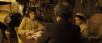 Movie still from “A Very Long Engagement” (2004), directed by Jean-Pierre Jeunet – A man and a woman are sitting at a table; Medium shot, Over the shoulder angle