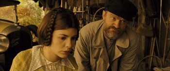 Movie still from “A Very Long Engagement” (2004), directed by Jean-Pierre Jeunet – A man and a woman sitting next to each other in a room; Close Up shot, Over the shoulder angle