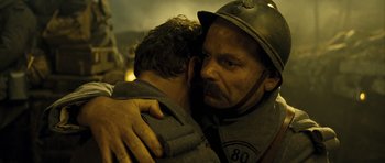 Movie still from “A Very Long Engagement” (2004), directed by Jean-Pierre Jeunet – A man is hugging a young boy in a uniform; Close Up shot, Over the shoulder angle