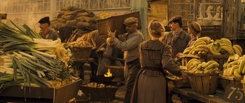 Movie still from “A Very Long Engagement” (2004), directed by Jean-Pierre Jeunet – A group of people standing around a fire pit; Wide shot, High angle