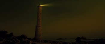 Movie still from “A Very Long Engagement” (2004), directed by Jean-Pierre Jeunet – A light shining on the top of an old lighthouse at night; Extreme Wide shot, Low angle