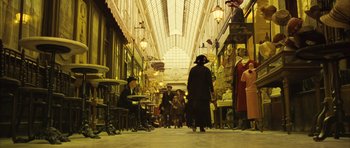 Movie still from “A Very Long Engagement” (2004), directed by Jean-Pierre Jeunet – A man in a long black coat walking down a street; Extreme Wide shot, High angle