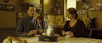 Movie still from “A Very Long Engagement” (2004), directed by Jean-Pierre Jeunet – A man and a woman sitting at a table; Medium shot, High angle