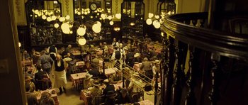 Movie still from “A Very Long Engagement” (2004), directed by Jean-Pierre Jeunet – A large group of people sitting at tables in a restaurant; Wide shot, High angle