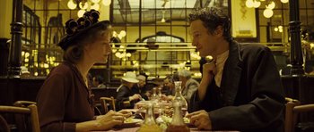 Movie still from “A Very Long Engagement” (2004), directed by Jean-Pierre Jeunet – A man and a woman sitting at a table in a restaurant; Medium shot, Over the shoulder angle