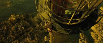 Movie still from “A Very Long Engagement” (2004), directed by Jean-Pierre Jeunet – A person climbing up the side of a light house; Extreme Wide shot, Overhead angle