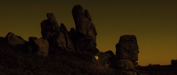 Movie still from “A Very Long Engagement” (2004), directed by Jean-Pierre Jeunet – A house sitting on top of a mountain at night; Extreme Wide shot, Low angle