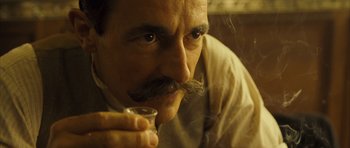 Movie still from “A Very Long Engagement” (2004), directed by Jean-Pierre Jeunet – A person holding a glass of wine; Close Up shot, Low angle