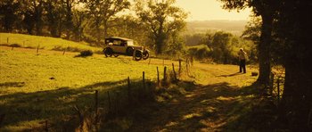 Movie still from “A Very Long Engagement” (2004), directed by Jean-Pierre Jeunet – An antique car is parked in a field; Extreme Wide shot, High angle