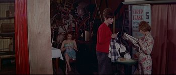 Movie still from “A Woman Is a Woman” (1961), directed by Jean-Luc Godard – Two women are sitting at a table in a restaurant; Wide shot, High angle