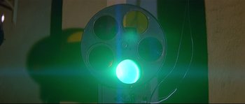 Movie still from “A Woman Is a Woman” (1961), directed by Jean-Luc Godard – A green light is seen through a movie projector; Extreme Close Up shot, Low angle