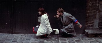 Movie still from “A Woman Is a Woman” (1961), directed by Jean-Luc Godard – A man and a woman kneeling on the ground; Medium shot, High angle