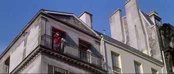 Movie still from “A Woman Is a Woman” (1961), directed by Jean-Luc Godard – A person standing on a balcony looking out of a window; Extreme Wide shot, Low angle