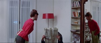 Movie still from “A Woman Is a Woman” (1961), directed by Jean-Luc Godard – A man and a woman are reading a newspaper together; Medium shot, Over the shoulder angle