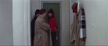 Movie still from “A Woman Is a Woman” (1961), directed by Jean-Luc Godard – A group of people standing in front of a door; Medium shot, Over the shoulder angle
