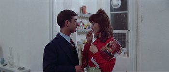 Movie still from “A Woman Is a Woman” (1961), directed by Jean-Luc Godard – A man and a woman standing next to each other in a room; Medium shot, Over the shoulder angle