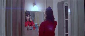 Movie still from “A Woman Is a Woman” (1961), directed by Jean-Luc Godard – A woman looking in the mirror in front of a mirror; Medium shot, Over the shoulder angle