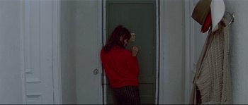 Movie still from “A Woman Is a Woman” (1961), directed by Jean-Luc Godard – A woman standing in front of a green door; Medium shot, High angle