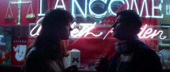 Movie still from “A Woman Is a Woman” (1961), directed by Jean-Luc Godard – A man and a woman are talking to each other in front of a neon sign; Medium shot, Over the shoulder angle
