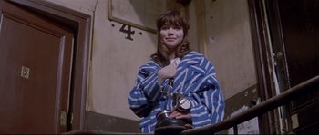 Movie still from “A Woman Is a Woman” (1961), directed by Jean-Luc Godard – A woman in a blue and white robe holding a clock; Medium shot, High angle