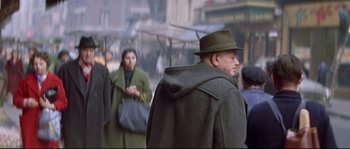 Movie still from “A Woman Is a Woman” (1961), directed by Jean-Luc Godard – A group of people walking down a street; Medium shot, Over the shoulder angle