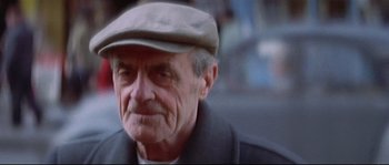 Movie still from “A Woman Is a Woman” (1961), directed by Jean-Luc Godard – An older man wearing a hat and a jacket; Close Up shot, Low angle