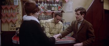 Movie still from “A Woman Is a Woman” (1961), directed by Jean-Luc Godard – A group of people sitting at a table; Medium shot, Over the shoulder angle
