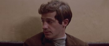 Movie still from “A Woman Is a Woman” (1961), directed by Jean-Luc Godard – A person wearing a jacket; Close Up shot, Over the shoulder angle