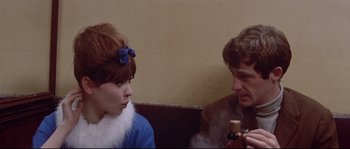Movie still from “A Woman Is a Woman” (1961), directed by Jean-Luc Godard – A man and a woman sitting next to each other; Close Up shot, Over the shoulder angle