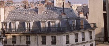 Movie still from “A Woman Is a Woman” (1961), directed by Jean-Luc Godard – A building that has a bunch of windows on it; Extreme Wide shot, High angle