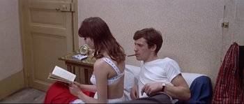 Movie still from “A Woman Is a Woman” (1961), directed by Jean-Luc Godard – A man and a woman sitting on a bed; Medium shot, High angle