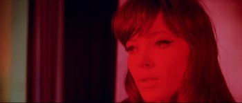Movie still from “A Woman Is a Woman” (1961), directed by Jean-Luc Godard – A woman's face in red light; Close Up shot, High angle