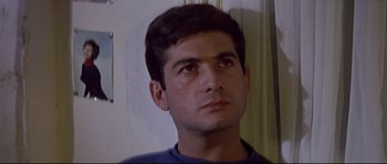 Movie still from “A Woman Is a Woman” (1961), directed by Jean-Luc Godard – A young man with short black hair looking up at the sky; Close Up shot, Low angle